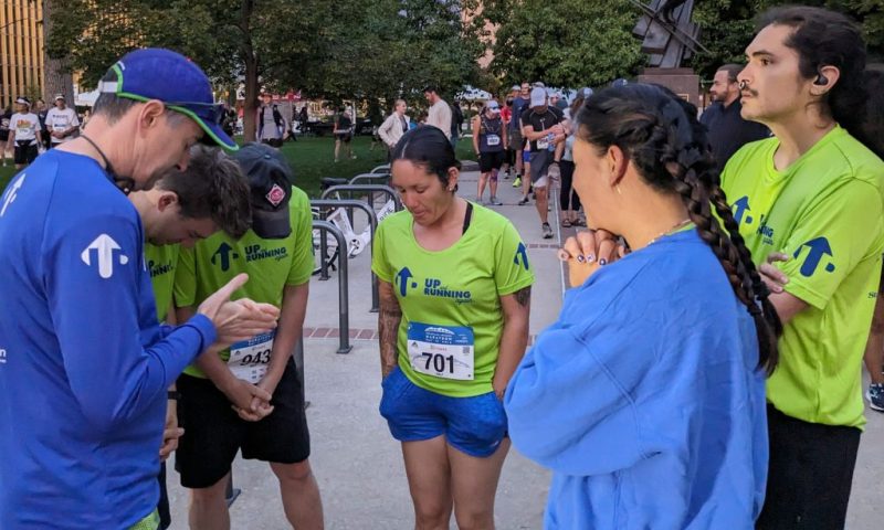 Group of runners praying before a race